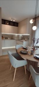 a kitchen with a wooden table with chairs and a dining room at Avisi Living in Trebinje