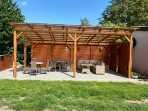 a wooden pergola with chairs and tables and a patio at Ubytování U Truhlářů Šaldorf in Nový Šaldorf