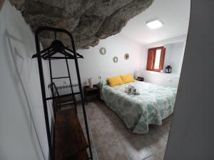 Un dormitorio con una cama con almohadas amarillas. en Casa Cueva EL PORTÓN, en Alcalá del Júcar