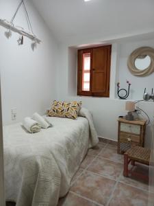 Un dormitorio con una cama y una ventana y una mesa. en Casa Cueva EL PORTÓN, en Alcalá del Júcar