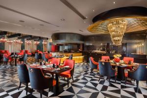 a restaurant with tables and chairs and a bar at Sheraton New Delhi Hotel in New Delhi