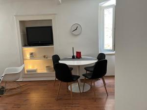 a dining room with a table and chairs and a tv at Apartman Passagio in Rovinj