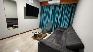 a living room with a couch and a television at Pavema Apartments in Paramaribo