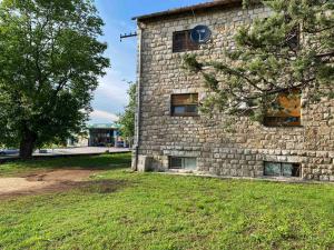 a stone building with a tree in front of it at Apartman JOVANA in Bileća