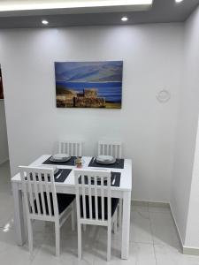 a white table with two chairs and a painting on the wall at Apartman JOVANA in Bileća +2 photos