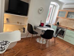 a kitchen with a table and chairs and a tv at Apartman Passagio in Rovinj