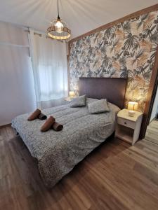 a bedroom with a bed with two slippers on it at Apartamentos Cuéntame Burgos - VUT in Burgos