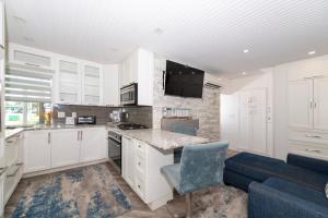 uma cozinha com armários brancos e um sofá azul em Tropic Isle Boutique Hotel em Hollywood