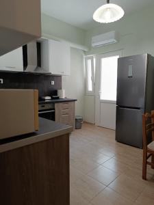 a kitchen with a stainless steel refrigerator and a table at Panos House - High Luxury Apartment in Tríkala