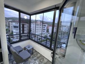 einen Balkon mit einem Stuhl und Stadtblick in der Unterkunft Kaya city rezidans in Nevşehir