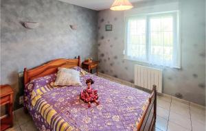 a doll sitting on a bed in a bedroom at Stunning Home In Quoux-haut-manil With Wifi And 2 Bedrooms in Haut-Maînil
