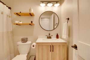 a bathroom with a toilet and a sink and a mirror at Lakeside Cabin Retreat with Private Hot Tub! in Lakeside +18 photos