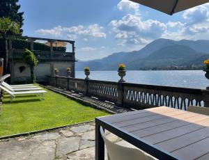 a bench sitting on the grass next to a body of water at Exclusive-LakeView Bella Vista Orta G&G in Omegna