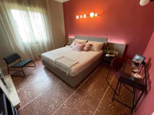 een slaapkamer met een groot bed met roze muren bij Casa indipendente, 250 m dalla spiaggia in Pisa