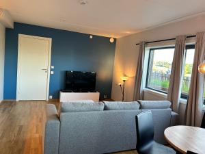 ein Wohnzimmer mit einem Sofa und einem Tisch in der Unterkunft Apartments in Kjeller Lillestrøm - New, Modern and Central in Lillestrøm