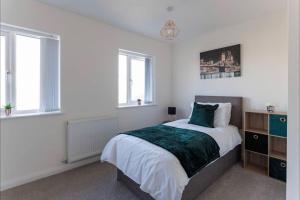 a white bedroom with a bed and two windows at Luxury 3-Bedroom, 2-Bathroom Home sleeps 7 people in Liverpool