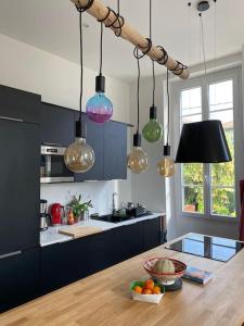 a kitchen with a table with a bowl of fruit and lights at Petit Paradis in Nice