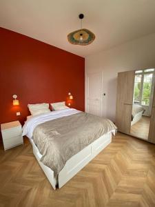 um quarto com uma cama grande e uma parede vermelha em Petit Paradis em Nice