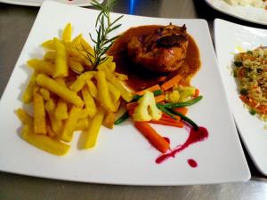 a plate of food with french fries and meat at Keije Resort Bunyonyi in Kabale