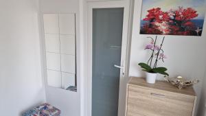 une porte menant à une salle de bains avec une plante sur une commode dans l'établissement Casa Teo, à Buzău