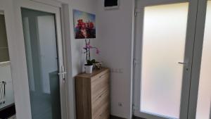 - un couloir avec une commode en bois et un miroir dans l'établissement Casa Teo, à Buzău