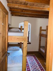 Pokój z 2 łóżkami piętrowymi i dywanem w obiekcie Guest House and Hostel VAL-MAR w Gjirokastrze