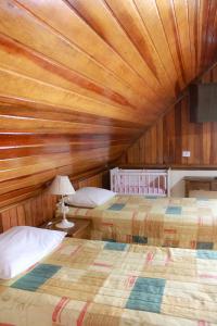a bedroom with two beds and a wooden ceiling at Pousada Villa Paty - Campos do Jordão in Campos do Jordão