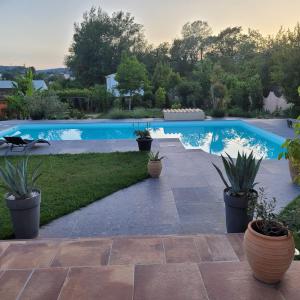 - une piscine dans une cour avec des plantes en pot dans l'établissement Villa L'Abaguie-Charmant logement au calme entre mer et montagne, à Cagnes-sur-Mer