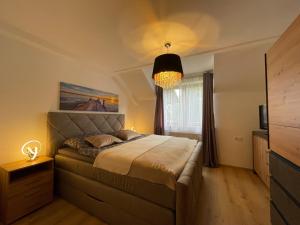 a bedroom with a large bed and a window at Vesterberg Apartments in Top Lage! Bike Garage Inklusive! in Schladming