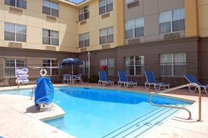 a pool at a hotel with chairs and an umbrella at Extended Stay America Suites - Las Vegas - East Flamingo in Las Vegas