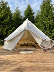 Restu Forrest Glamp في أوتيبا: خيمة بيضاء وامامها كرسي