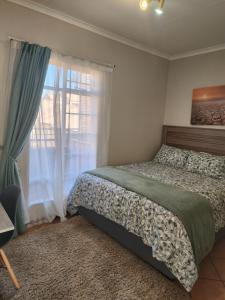 a bedroom with two beds and a window at Mooikloof Village Apartment with Solar Backup in Pretoria