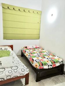 a bedroom with two twin beds and a window at Casa en Condominio Santa Helena in Yaguará
