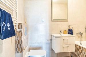 a bathroom with a toilet and a sink and a mirror at Yacht Apartments in Wilkasy