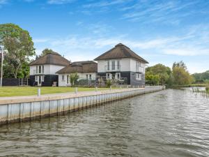 a row of houses next to a river at Broad View in South Walsham