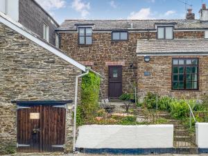 an old brick house with a wooden door at Florin Cottage in Lerryn