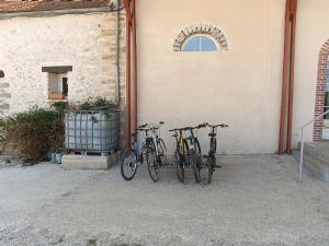 tres bicicletas están estacionadas al lado de un edificio en Chambre d'hôtes Le Domaine des Hirondelles, en Champcenest