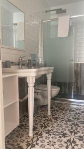 a bathroom with a sink and a tub and a toilet at Hera Hotels Alaçatı in Cesme