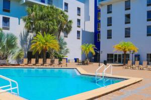 a swimming pool in front of a building with palm trees at Southbank Hotel by Marriott Jacksonville Riverwalk in Jacksonville