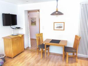 ein Esszimmer mit einem Tisch und Stühlen sowie einem TV in der Unterkunft Peaceful Holiday Home in Ruhpolding with Sauna in Ruhpolding