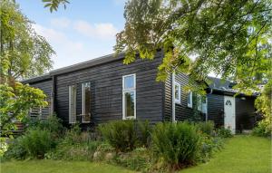 une maison noire avec un jardin en face dans l'établissement Amazing Home In Hornslet With Kitchen, à Hornslet