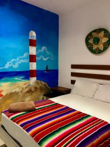 1 dormitorio con 1 cama y una pintura de un faro en Villa Leo en Cancún