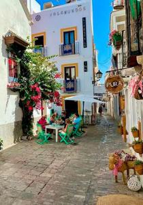 un groupe de personnes assises à des tables dans une ruelle dans l'établissement Vagamundos, à Tarifa