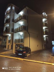 un'auto parcheggiata di fronte a un edificio di notte di Vila Pčelica Petra a Soko Banja