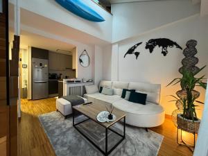 salon z białą kanapą i stołem w obiekcie Maravilloso Ático-duplex w mieście Vigo