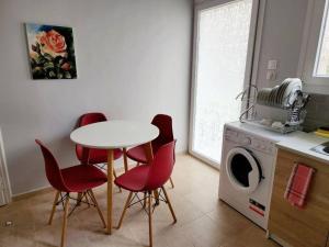 a kitchen with a table and chairs and a washing machine at Kallithea’s Heart greendom in Athens
