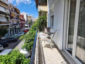 un balcone con tavolo e sedie su una strada della città di Kallithea’s Heart greendom ad Atene