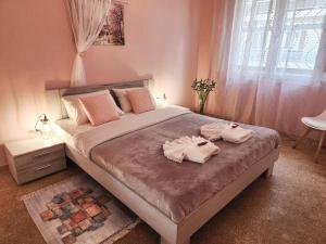 a bedroom with a large bed with two towels on it at Kallithea’s Heart greendom in Athens