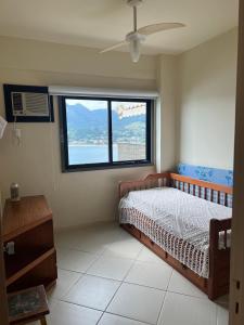um quarto com uma cama e uma grande janela em Porto real resort em Mangaratiba