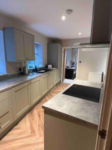 a kitchen with white cabinets and a counter top at Cosy newly renovated 3 bedroom house - Town centre Horncastle in Lincolnshire